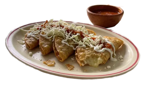 Plato de tacos dorados con repollo, crema, queso y salsa, y una salsera de barro